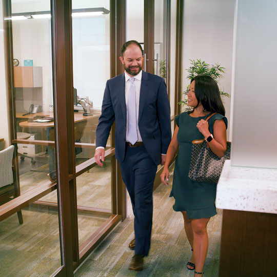 Man and woman walking in an office hallway