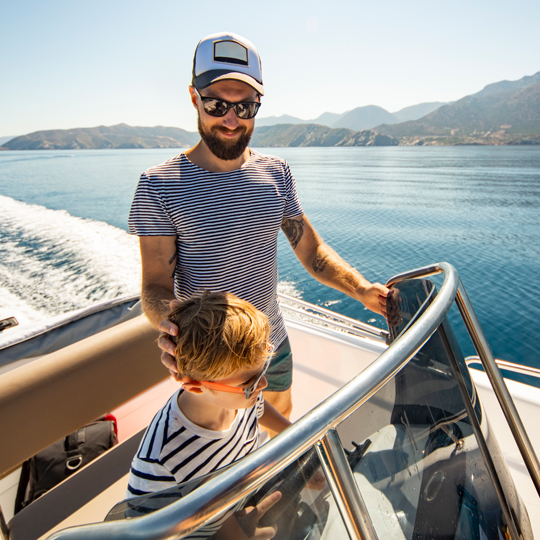 Man and child on a boat in the water outside