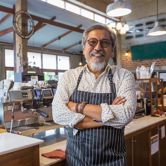 Man looking at camera and smiling in a coffee shop