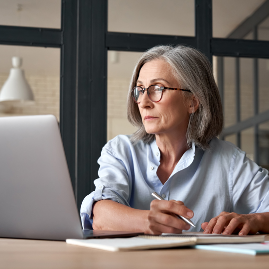 Older woman working and looking at a computer screen