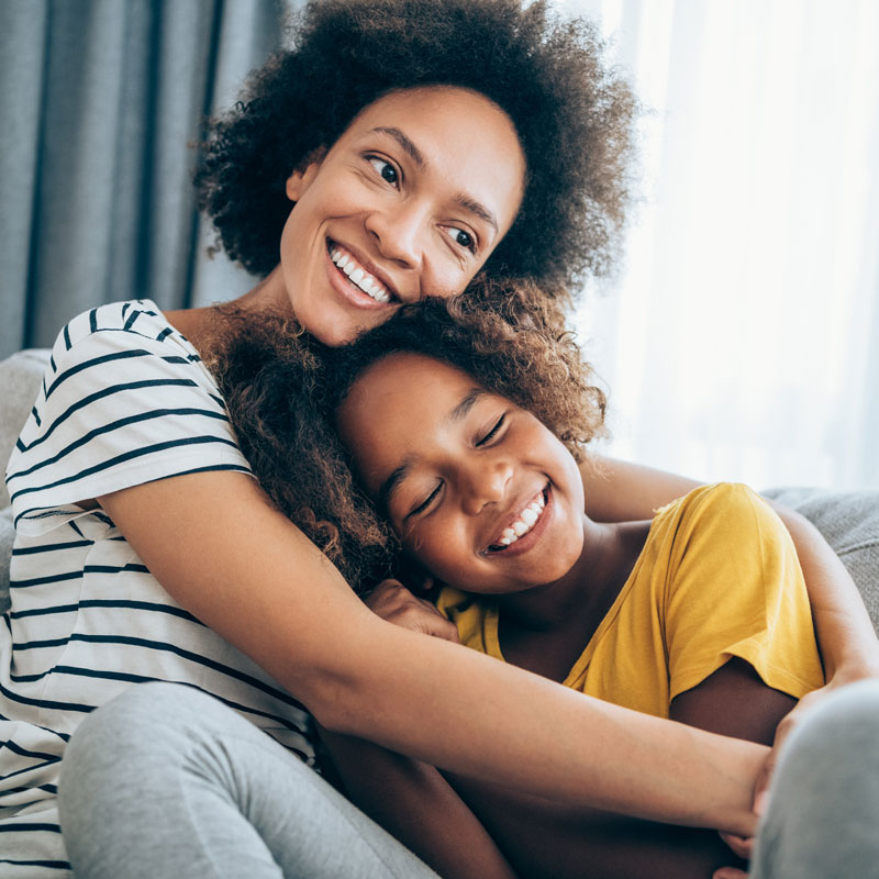 Woman and child sitting on a couch and smiling